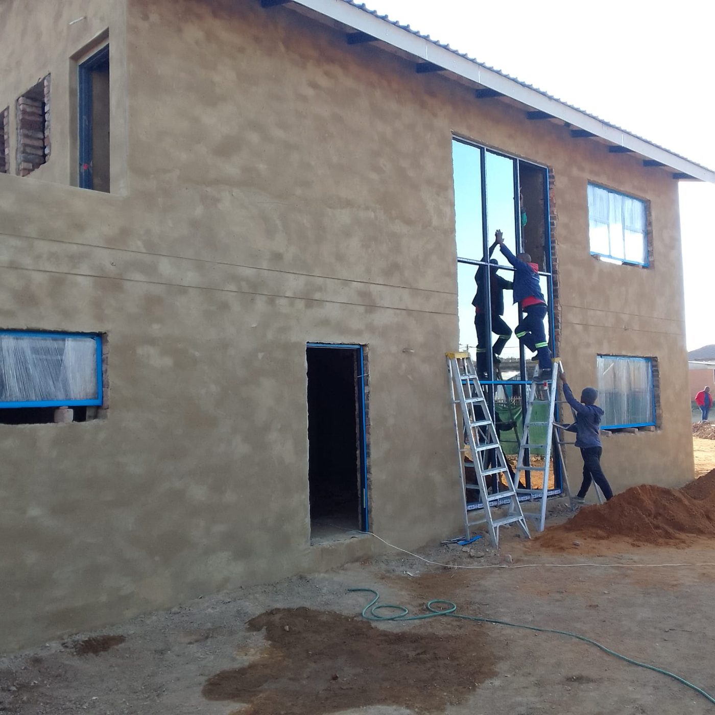 Plastering team on scaffolding finishing external walls