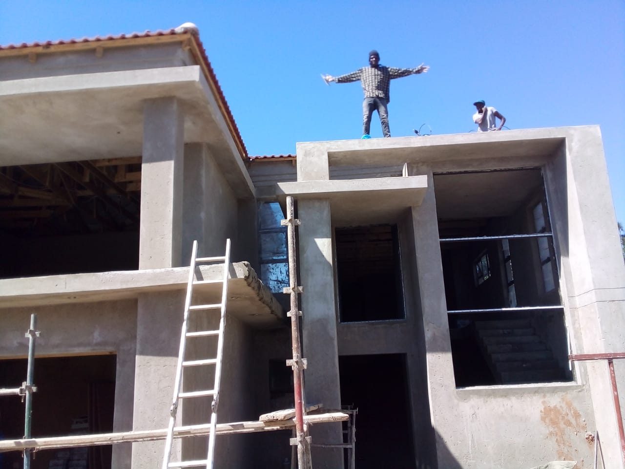 Double-storey house under construction with team on site
